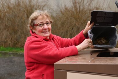 Andrée Le Touzo vide son bioseau individuel dans le contenant collectif extérieur. - Agrandir l'image, fenêtre modale